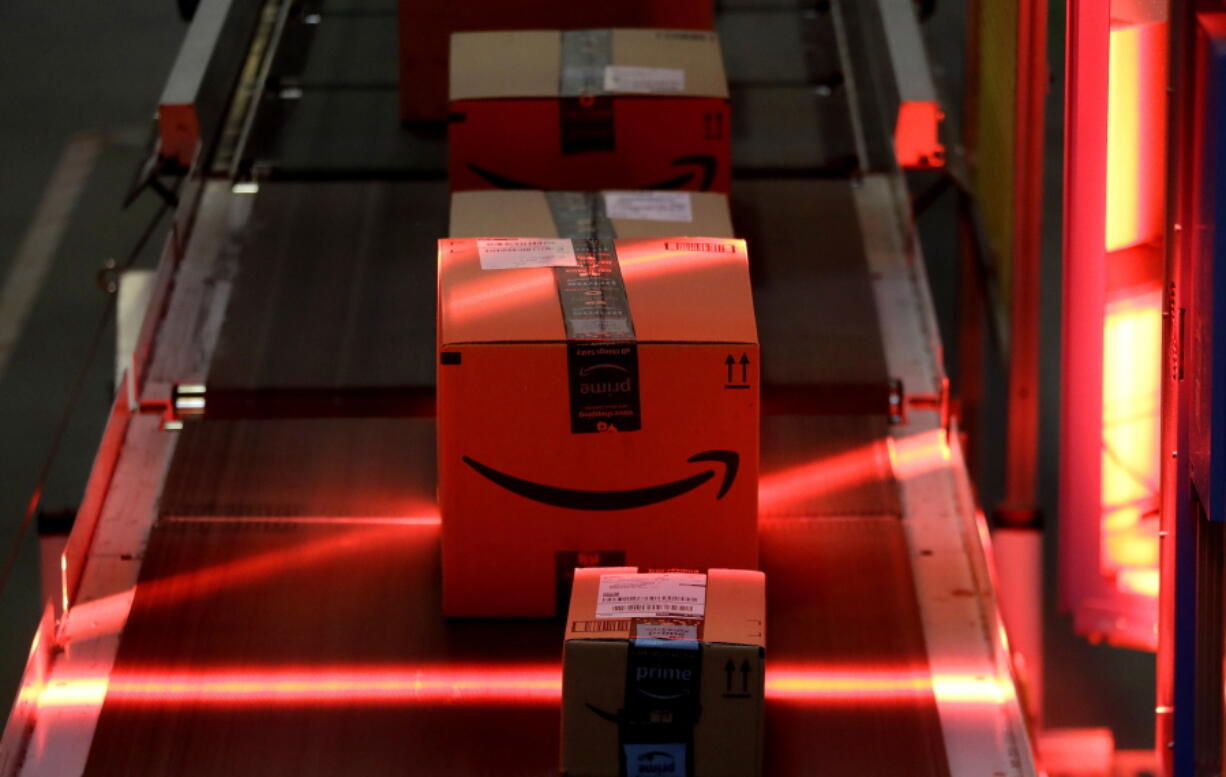 Packages riding on a belt are scanned to be loaded onto delivery trucks at the Amazon Fulfillment center in Robbinsville Township, N.J. Amazon is holding a giant job fair Wednesday, Aug. 2, and plans to make thousands of job offers on the spot at nearly a dozen U.S. warehouses.