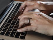 In this Monday, June 19, 2017, photo, a person types on a laptop keyboard, in North Andover, Mass. The American workplace is grueling, stressful and surprisingly hostile. So finds an in-depth study of 3,066 U.S. workers, released Monday, Aug. 14, 2017, by the Rand Corp., Harvard Medical School and the University of California, Los Angeles.