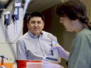 Shoukhrat Mitalipov, left, talks July 31 with research assistant Hayley Darby in the Mitalipov Lab at OHSU in Portland. Mitalipov led a research team that, for the first time, used gene editing to repair a disease-causing mutation in human embryos, laboratory experiments that might one day help prevent inherited diseases from being passed to future generations.