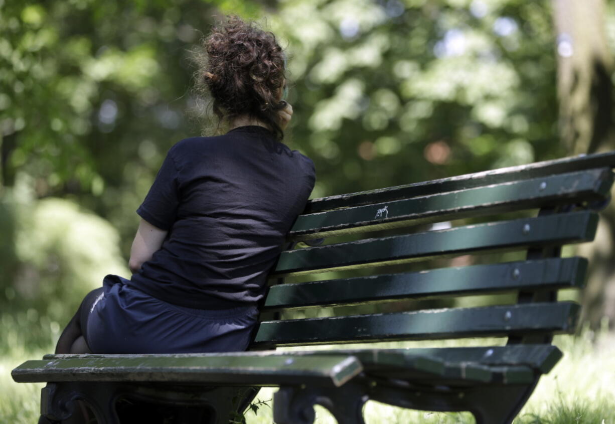 In this Tuesday, May 23, 2017 photo, a young Turkish artist sits on a bench during an interview with The Associated Press in Berlin. She asked for anonymity, fearing repercussions for her family back home. Germany has become the top destination for political refugees from Turkey, many of them formerly part of Turkey’s secular elite. Among the more than 3,000 asylum-seekers who arrived so far this year are diplomats, civil servants, military members, academics, artists, journalists and judges.