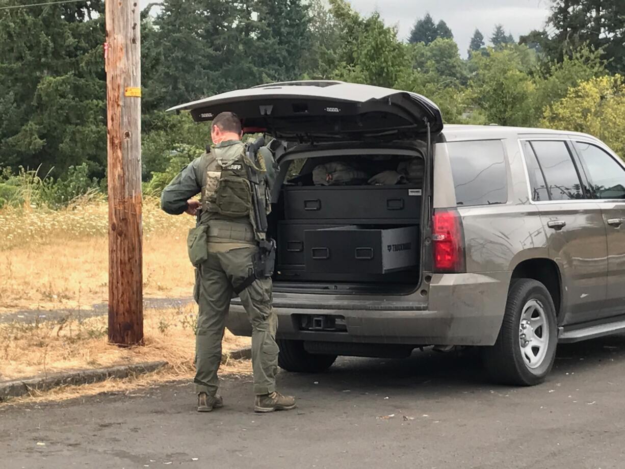 A member of a Vancouver Police Department SWAT unit arrives at the Cedar Lane Apartments Saturday morning in Vancouver. A reported disturbance with a weapon brought officers to the scene around 9 a.m.