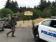 A member of a Vancouver Police Department SWAT unit carrying a chainsaw and tactical weapons responds to a domestic disturbance at the Cedar Lane Apartments.