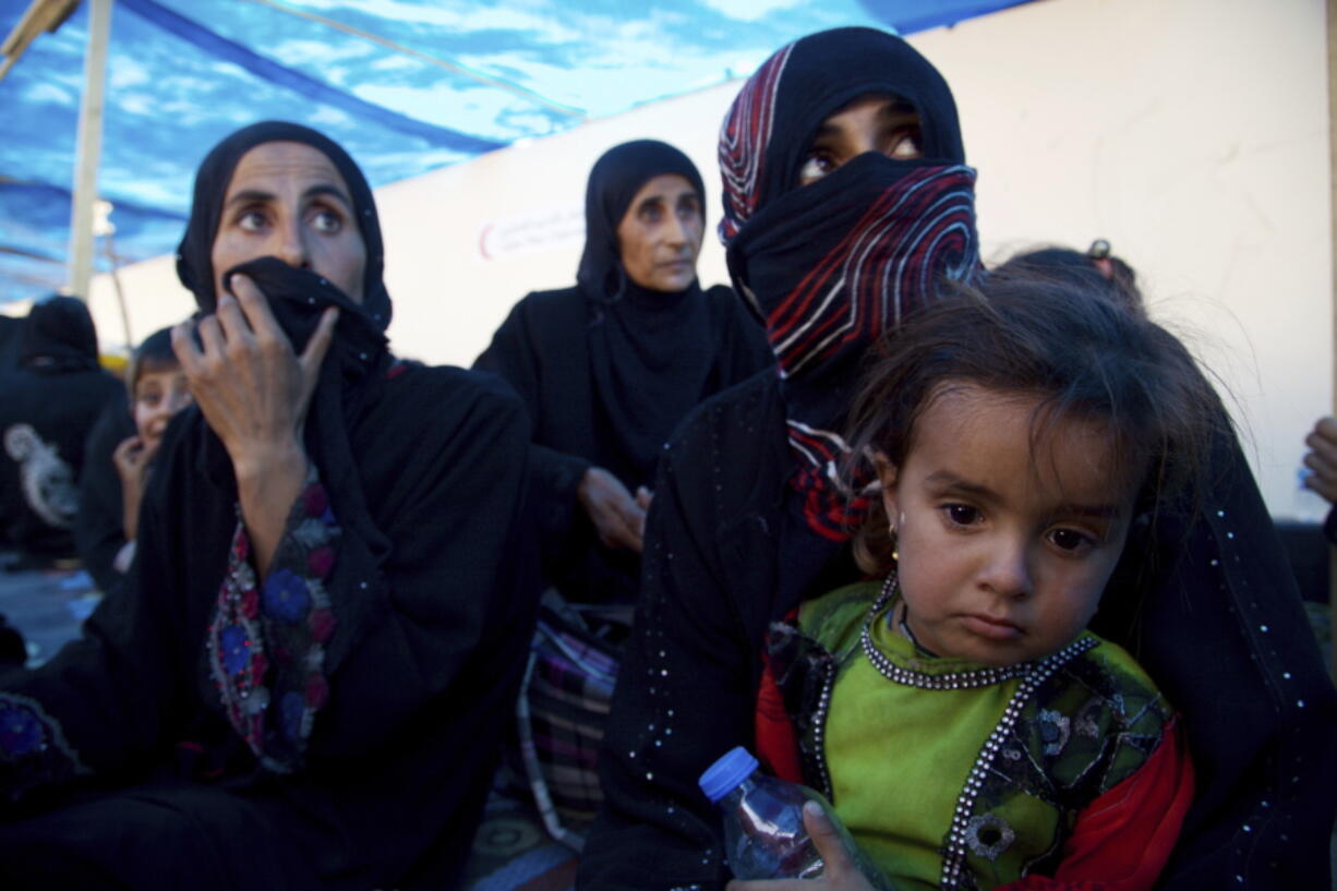 Displaced Iraqi women and children sit on the ground at a collection point west of Mosul on the outskirts of Tal Afar, Iraq. Iraq’s prime minister declared the town of Tal Afar “fully liberated” from the Islamic State group after a nearly two-week operation. Haider al-Abadi said Thursday, Aug. 31, 2017, that Iraqi troops “eliminated and smashed Daesh terrorists” in al-Ayadia district, about 10 kilometers (6 miles) northwest of Tal Afar, where the militants fled last week. Daesh is the Arabic acronym for IS.