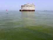 The water intake crib for the city of Toledo, Ohio, is surrounded by an algae bloom on Lake Erie, about 2.5 miles off the shore of Curtice, Ohio. Researchers are working on creating an early warning system that can spot when algae begins showing up on hundreds of lakes across the U.S., using real-time data from satellites that already monitor harmful algae hotspots on Lake Erie in Ohio and on the Chesapeake Bay along the East Coast. (AP Photo/Haraz N.