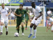 Portland Timbers midfielder Diego Valeri, second from left, drives between Seattle Sounders midfielder Osvaldo Alonso, left, and defender Nouhou (5) in the first half of an MLS soccer match, Sunday, Aug. 27, 2017, in Seattle. (AP Photo/Ted S.