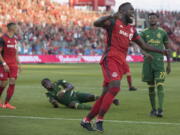 Toronto FC forward Jozy Altidore celebrates after Justin Morrow, left, scored against the Portland Timbers during the second half of an MLS soccer match Saturday, Aug. 12, 2017, in Toronto.