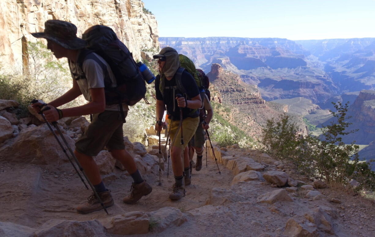 FILE - In this July 27, 2015, file photo, a long line of hikers head out of the Grand Canyon along the Bright Angel Trail at Grand Canyon National Park, Ariz. The U.S. federal government announced Wednesday, Aug. 16, 2017, it will eliminate a policy it put in place to allow national parks like the Grand Canyon to ban the sale of bottled water in an effort to curb litter. (AP Photo/Ross D.