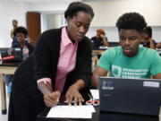 Britney Wray, a math teacher at Washington Leadership Academy in Washington, D.C., helps sophomore Kevin Baker, 15, with a math problem during class.