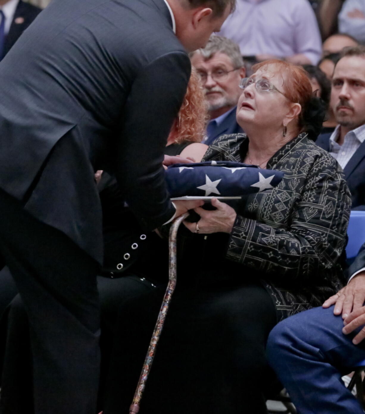 Rebecca Crofts accepts a folded American flag in honor of her father, World War II Staff Sgt. Bernard Snow, during a ceremony recognizing National Purple Heart Day, Monday Aug. 7, 2017, at Federal Hall in New York. The ceremony reunited families with previously lost Purple Hearts belonging to war veterans.