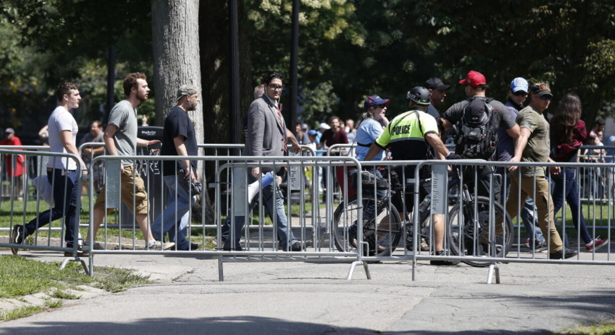 Organizers depart a "Free Speech" rally staged by conservative activists on Boston Common, Saturday, Aug. 19, 2017, in Boston. One of the planned speakers of a conservative activist rally that appeared to end shortly after it began says the event "fell apart." Dozens of rallygoers gathered Saturday on Boston Common, but then left less than an hour after the event was getting underway. Thousands of counterprotesters had also gathered.