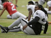 Oakland Raiders running back Marshawn Lynch stretches during an NFL football training camp Friday, Aug. 4, 2017, in Napa, Calif.