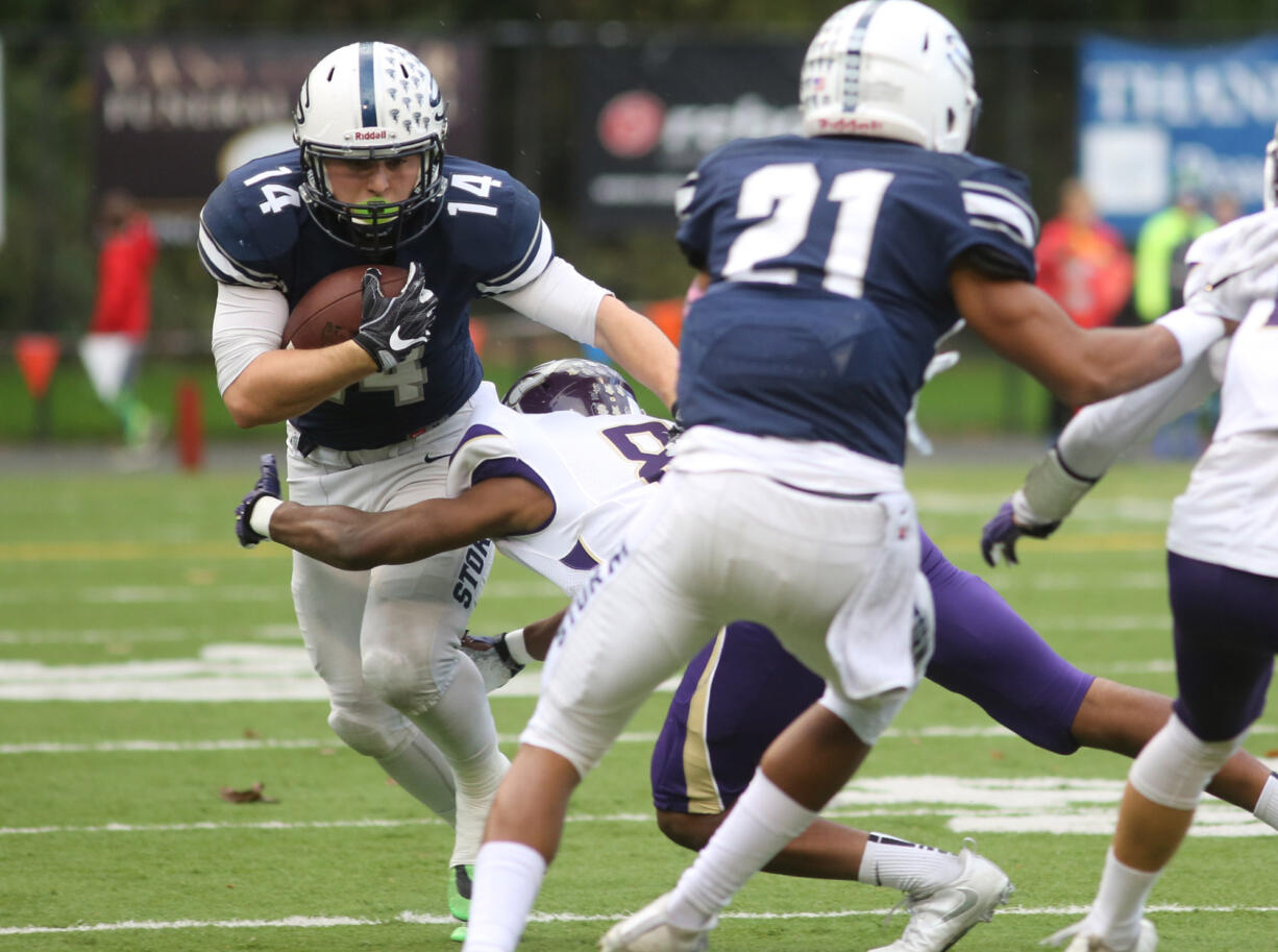 Skyview's Travis Yajko runs with the ball as  Lake Stevens' Jalen Thibou tries to tackle him in the football 4A state quarterfinals at Kiggins Bowl in Vancouver on Saturday, Nov. 19, 2016.