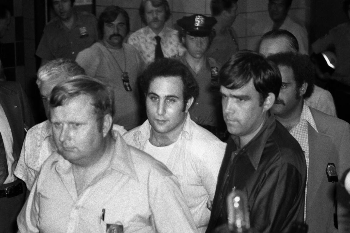 David Berkowitz, center, the tabloid-loving, police-taunting “Son of Sam” killer, is escorted into a courthouse in the Brooklyn borough of New York on Aug. 11, 1977 .