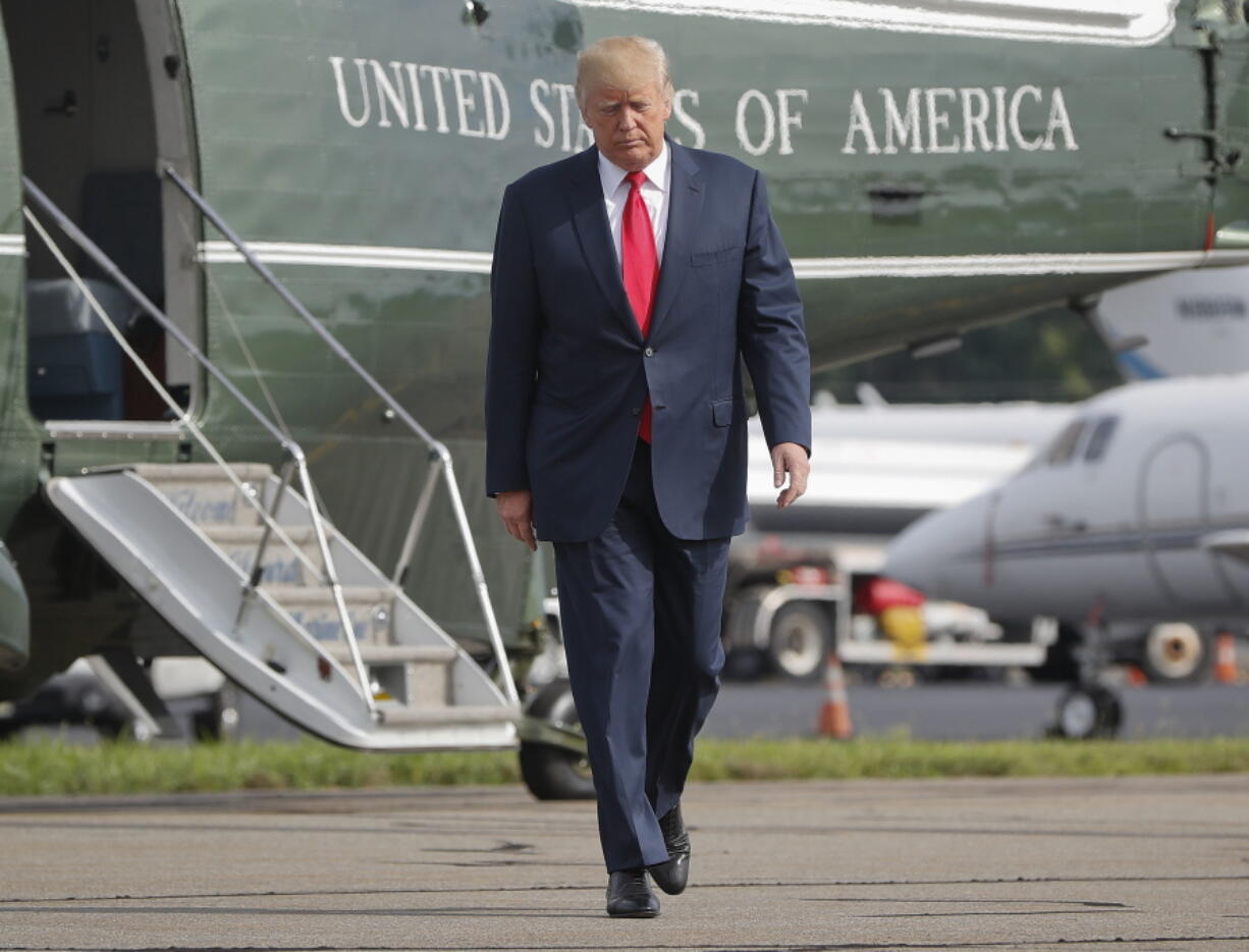 FILE - In this Aug. 14, 2017 file photo, President Donald Trump walks across the tarmac from Marine One to board Air Force One at Morristown Municipal Airport in Morristown, N.J. Bombarded by the sharpest attacks yet from fellow Republicans, President Donald Trump on Thursday, Aug. 17, 2017, dug into his defense of racist groups by attacking members of own party and renouncing the rising movement to pull down monuments to Confederate icons.