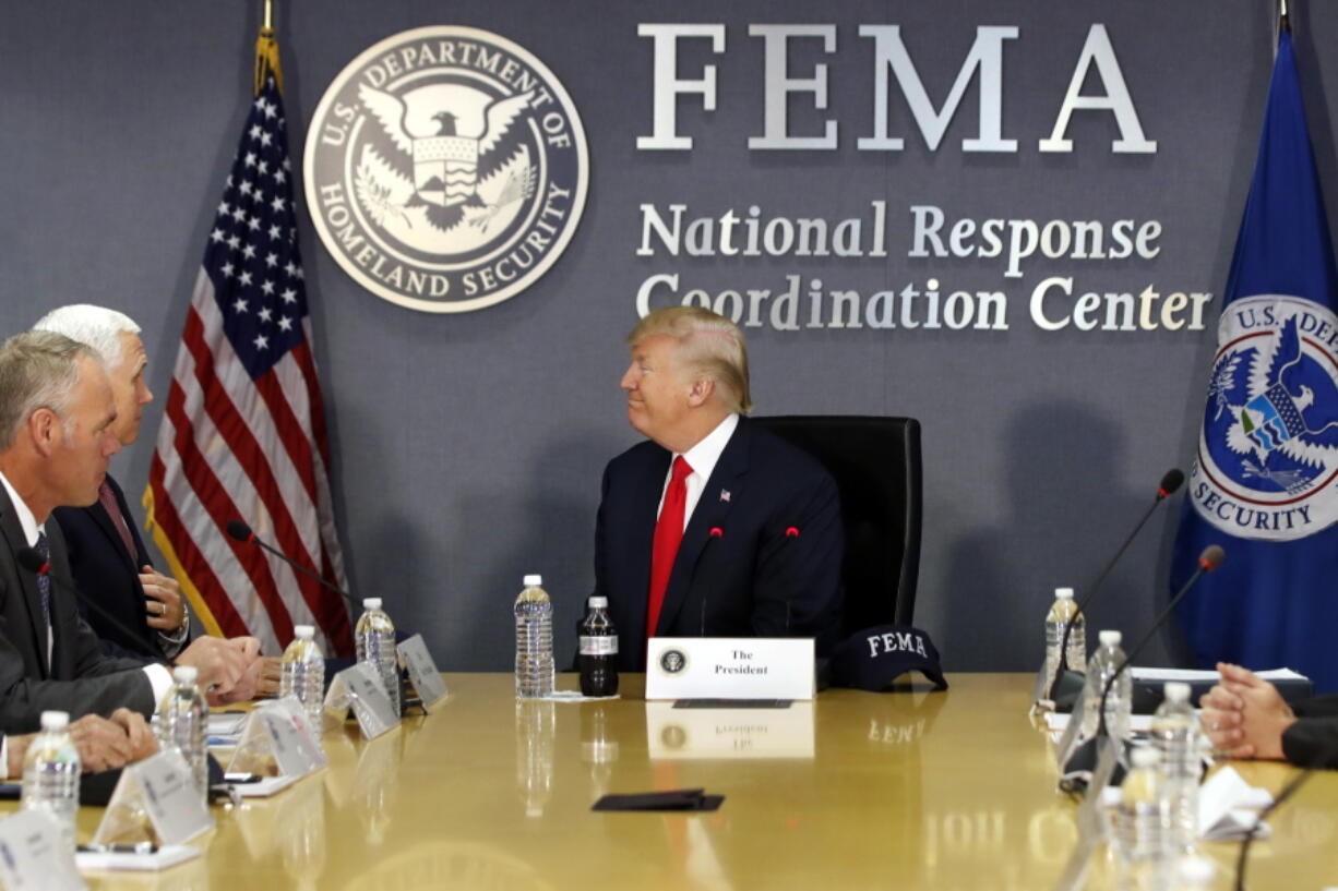 President Donald Trump turns to Vice President Mike Pence as they meets with emergency officials to discuss the hurricane season Friday at Federal Emergency Management Agency headquarters in Washington.