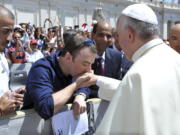 Irish psychotherapist Vincent Doyle kisses Pope Francis’ hand in 2014 during a general audience in St. Peter’s Square, at the Vatican. Doyle, who was fathered by a priest, started the online resource Coping International for children of priests and their mothers.