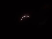 The moon eclipses the sun above the Vancouver Community Library on Monday morning. The next solar eclipse will be viewable from parts of the United States on April 8, 2024.