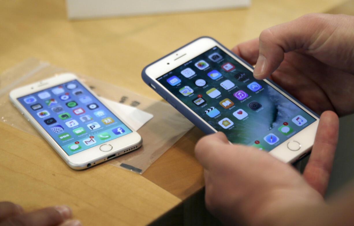 A customer sets up a new iPhone 7 Plus, right, as he switches from the iPhone 6 at an Apple Store in Chicago.