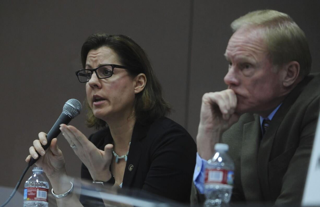 Sen. Ann Rivers, left, with Rep. Paul Harris, answers questions as teachers, parents and public school supporters rally in March at a town hall with legislators at Roosevelt Elementary in Vancouver.