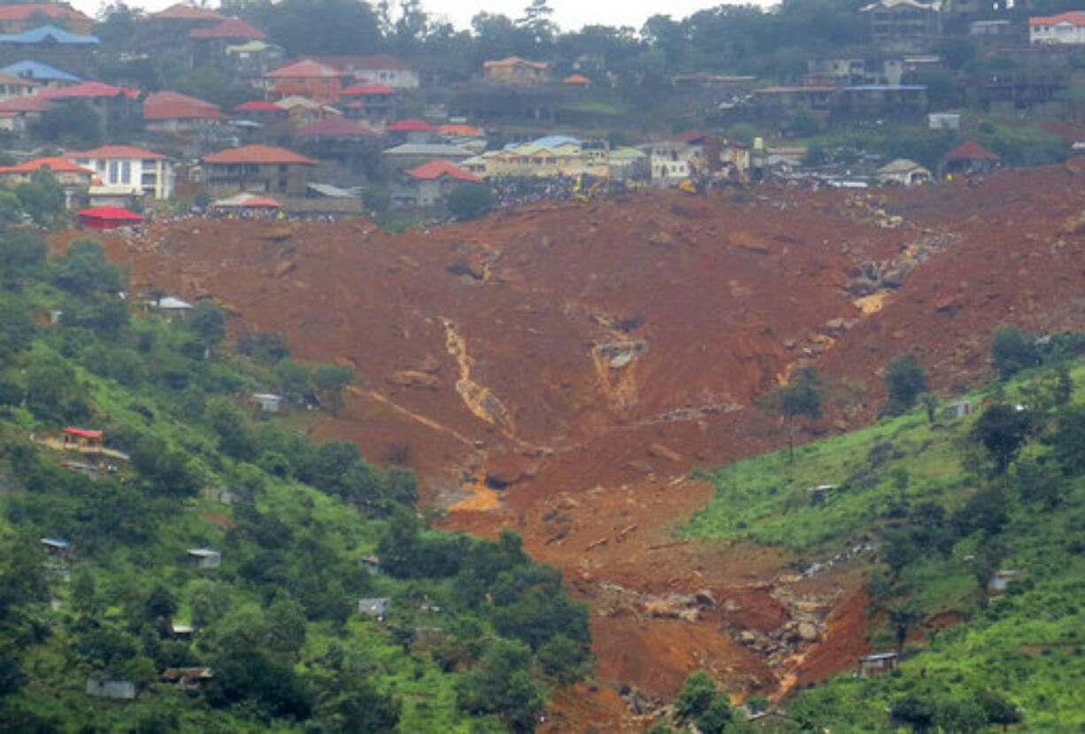 Rescue workers gather at the summit of a mudslide in Regent, east of Freetown, Sierra Leone, Monday, Aug. 14 , 2017. Mudslides and torrential flooding killed many people in and around Sierra Leone's capital early Monday following heavy rains, with many victims thought to be trapped in homes buried under tons of mud.