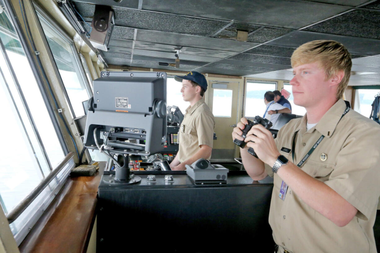 In the wheelhouse of the ferry Issaquah, interns John Bresnahan, left, at the wheel, and Sebstian Jewell, right, approach Fauntleroy Ferry Terminal.