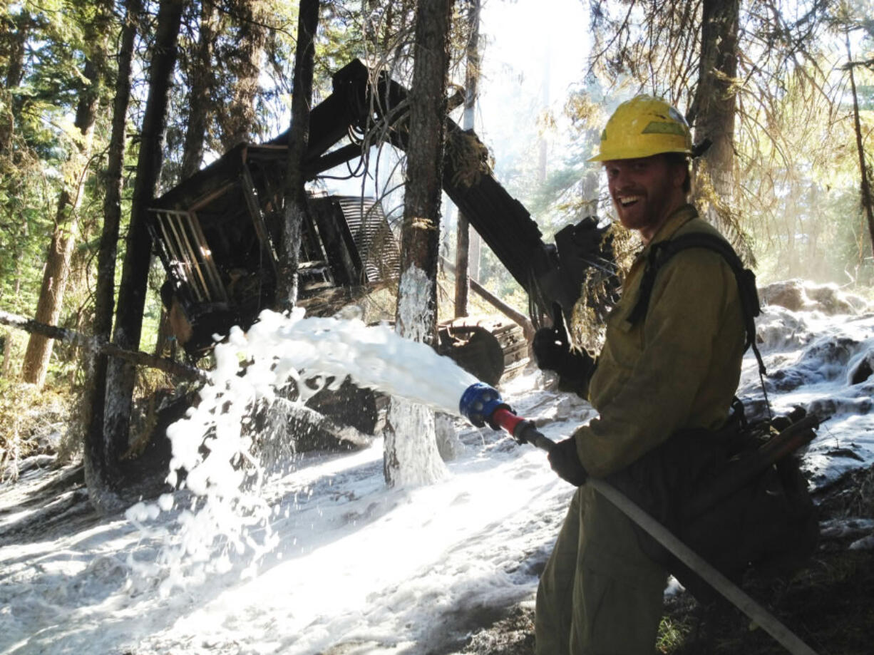 Andy Matarrese sprays foam around a piece of logging equipment that caught fire in 2012. Matarrese was a wildlands firefighter before becoming a reporter.