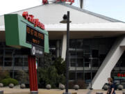 In this March 16, 2017 photo, a pedestrian walks past KeyArena in Seattle. Tim Leiweke, head of the Oak View Group, is expected to submit a proposal for a renovation of KeyArena, which formerly was home to the NBA’s Seattle SuperSonics. Seattle is in the midst of an arena showdown with three groups putting forth proposals around two sites to build the possible future home for teams from in the NBA basketball and NHL hockey leagues. (AP Photo/Ted S.