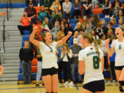 From left, Nicole Guthrie, Vanessa Franke and Emma Swett celebrate a point for Woodland in a volleyball match against Ridgefield on Thursday.