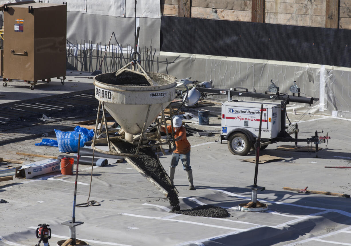 A construction worker pours asphalt into a parking lot construction site at the Vancouver waterfront between Block 6 and 8 in August. Construction was among the fields adding jobs in Clark County in August.