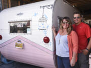 René Perret and Jeremy Ralston, owners of Down River Vintage Trailer Restoration, stand next to a 1959 Aloha trailer they're renovating in their shop in Woodland.