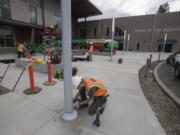 Andrew Stewart of Prairie Electric helps prepare the exterior lighting of the replacement Hockinson Middle School. Crews have been working frantically to finish everything because of time lost after a hard-hitting winter.