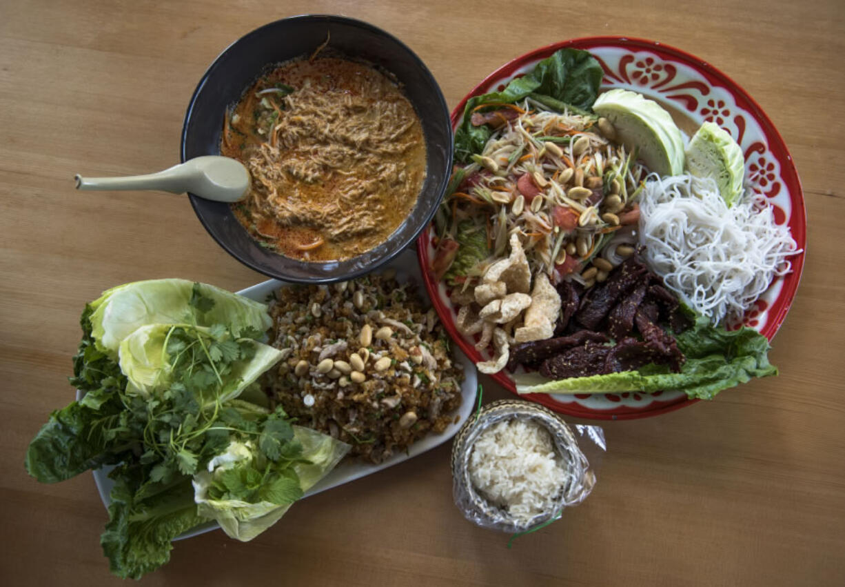 The Nem Kao, red curry chicken noodle soup and green papaya salad Som Tum Taad plate at Nom Nom in downtown Vancouver.