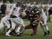 Camas defenders gang tackle Central Catholic's Miles Jackson at Hillsboro Stadium.