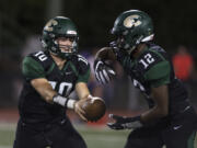 Evergreen’s Triston Fich (10) hands off to Zyell Griffin (12) during Friday night’s game against Columbia River at McKenzie Stadium on Sept. 1, 2017.