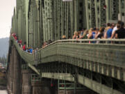 Hundreds gather on the pedestrian sidewalk of the Interstate 5 Bridge on Monday to join hands and say the Serenity Prayer in celebration of their recovery from addiction.