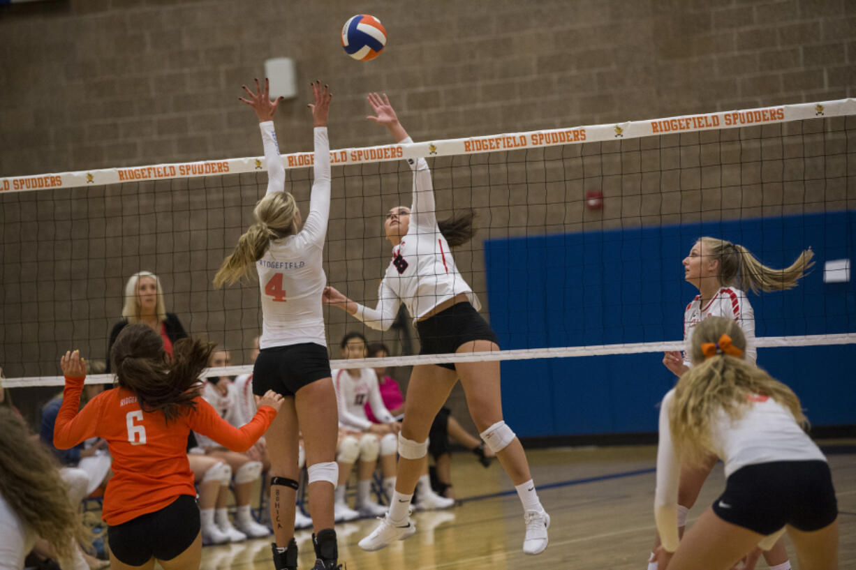 Ridgefield’s Anika Nicoll (4) goes up to block a hit from Camas’ Whitney Quist (8) during Tuesday’s volleyball season opener at Ridgefield High School. Camas won 3-1.