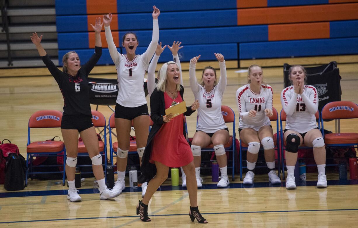 Camas’ varsity volleyball head coach Michelle Allen cheers with Camas players after scoring a critical point during Tuesday’s volleyball season opener against Ridgefield at Ridgefield High School, September 5, 2017.