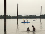 A smokey haze falls over Vancouver Lake as people enjoy the sandy beach and cool water on Monday, Sept. 4, 2017.