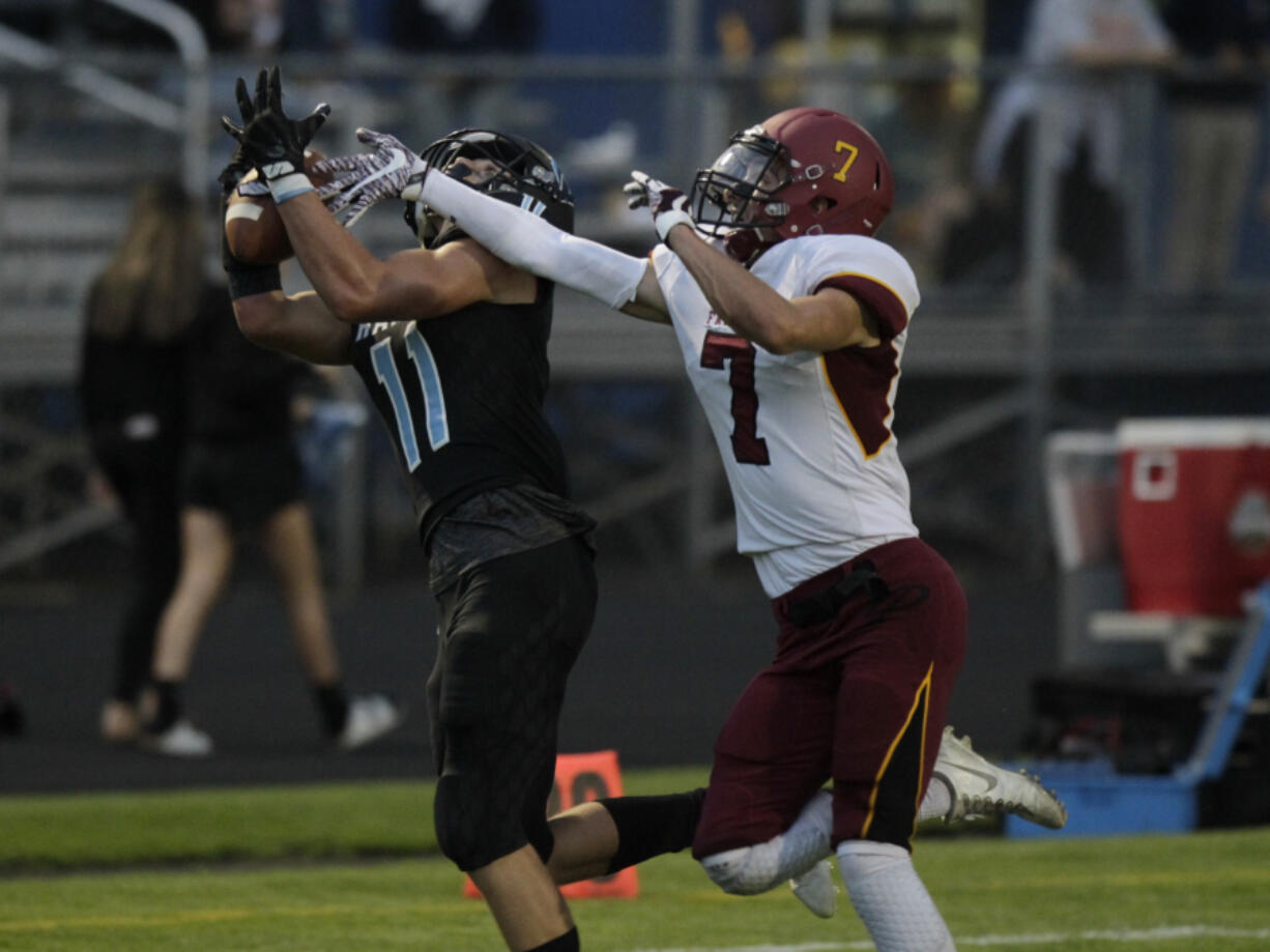 Hockinson wide receiver Sawyer Racanelli (left) hauls in a pass as Prairie’s Nolan Mickenham defends.