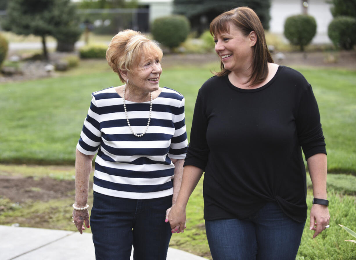 Marian Markley, 77, left, walks Thursday with her daughter Val Dewitz, 44, at Dewitz’s home in Ridgefield. Markley was adopted at birth, but with the help of Dewitz, they were able to locate and meet Markley’s biological sister last month in California.