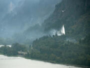 A helicopter makes a water drop on the Eagle Creek Fire on Thursday in this view from the Cape Horn overlook along Highway 14. Improved conditions also allowed water drops on the Archer Mountain Fire in western Skamania County.