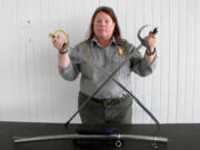 Elaine Dorset, National Park Service archaeologist, with two replica sabers that will help re-enactors represent an Army dragoon unit at Fort Vancouver in the 1850s. The saber with the gold-colored bell guard will be carried by re-enactors. The one with the silver-colored bell guard and rubber tip is a training saber.