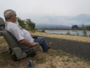 Sitting in Stevenson, Robert Loomis of Cascade Locks, Ore. looks at the Eagle Creek fire creeping toward his home on Thursday. Loomis moved to Cascade Locks from Hood River, Ore., just a month ago for a quieter place, but he is worried that he now might have to find another place to live.