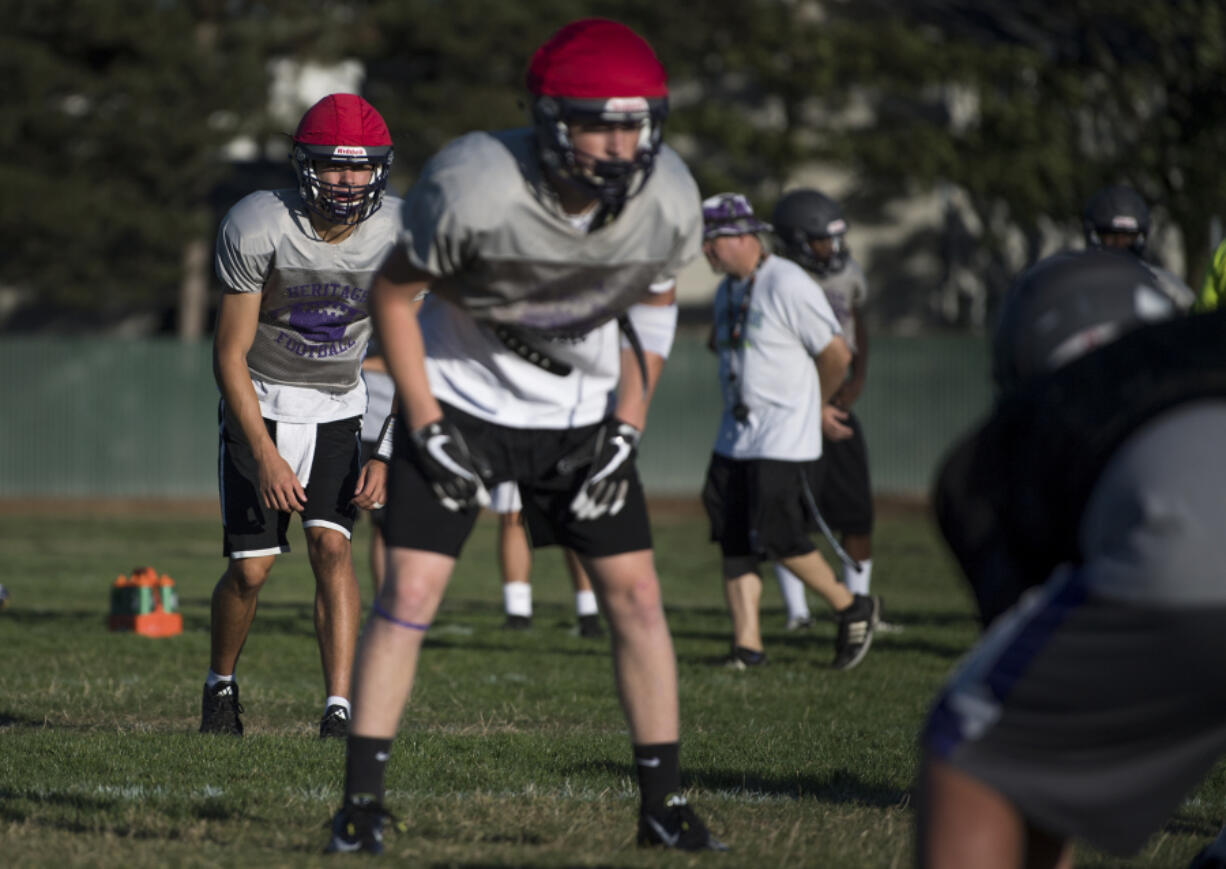 Heritage High School quarterback Michael Taras, back left, and receiver Robbie Meadors, front center, run drills during practice in Vancouver on Tuesday afternoon, Sept. 12, 2017.