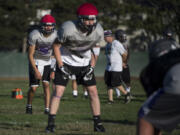 Heritage High School quarterback Michael Taras, back left, and receiver Robbie Meadors, front center, run drills during practice in Vancouver on Tuesday afternoon, Sept. 12, 2017.