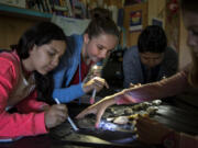 Wy’east Middle School sixth-graders Liz Rangel, from left, Grace Smith, Diego Ku Bauzo and Audrey Shillinger dust off fossils during Evergreen Public Schools’ dual immersion class on Tuesday morning. The students have been in the same class, where they are instructed in both Spanish and English, since 2011 when they entered kindergarten. “We’re like family,” Grace said.