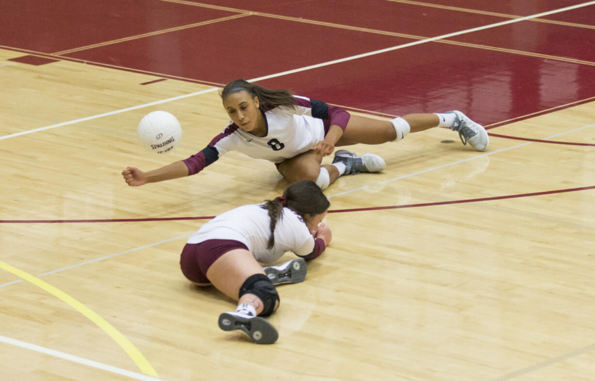 Prairie's Zoe Mcbride (8) digs for the ball alongside Shelby Kocin (4) during Thursday's volleyball game at Prairie High School on Sept. 14, 2017. Prairie won all three sets against Camas.