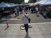 Jack Spadolini, 18, plays cover songs on his guitar for passers-by at the Vancouver Farmers Market on a recent Saturday. Spadolini has been performing at the market for about four years, and plans to use the money on an upcoming work trip to Australia and later for college.