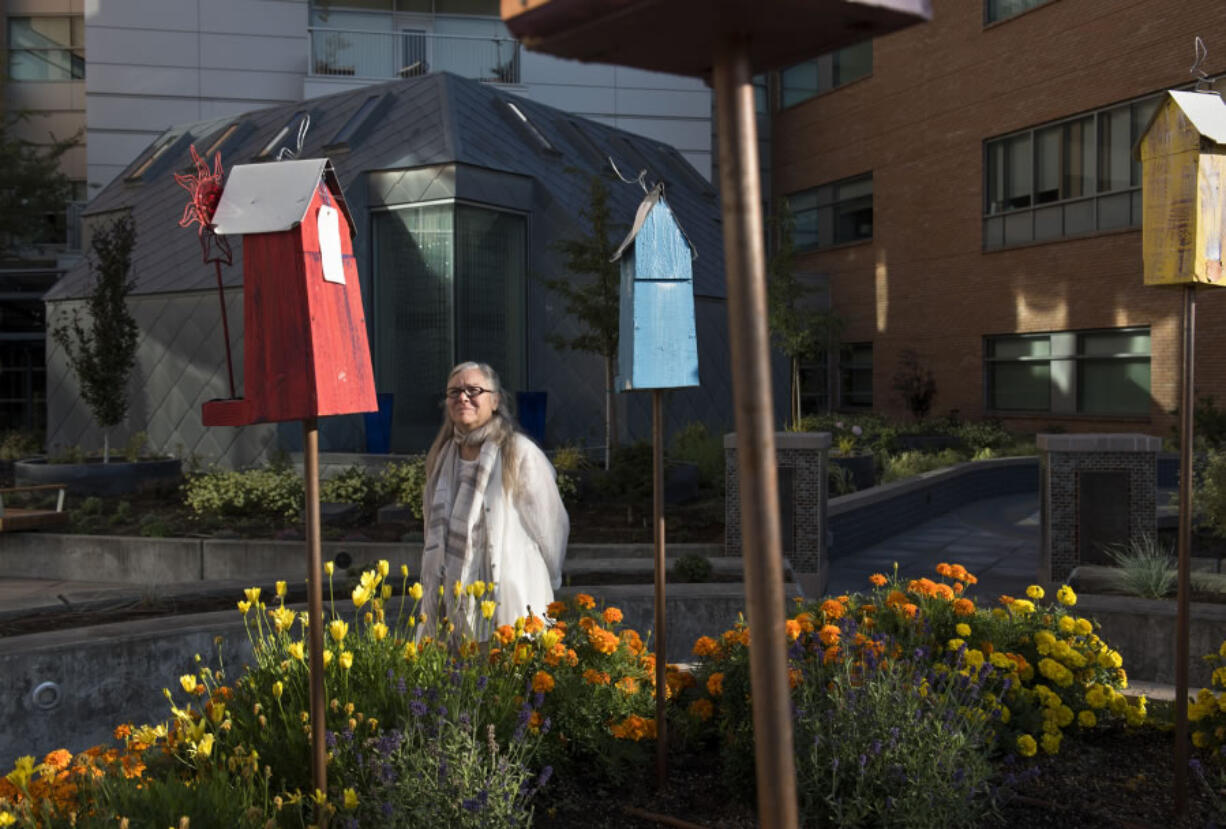 Marg Nelson of Vancouver, a spiritual health volunteer, admires the colorful birdhouses in the newly renovated healing garden Friday morning at Legacy Salmon Creek Medical Center. Nelson sponsored the creation of a labyrinth in the garden, which will be officially unveiled to the community at an event at 3:30 p.m. Wednesday.