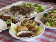 Spring rolls, center, served with spicy chicken, clockwise from left, beef broccoli and vegetable yakisoba at Du’s Teriyaki in central Vancouver.